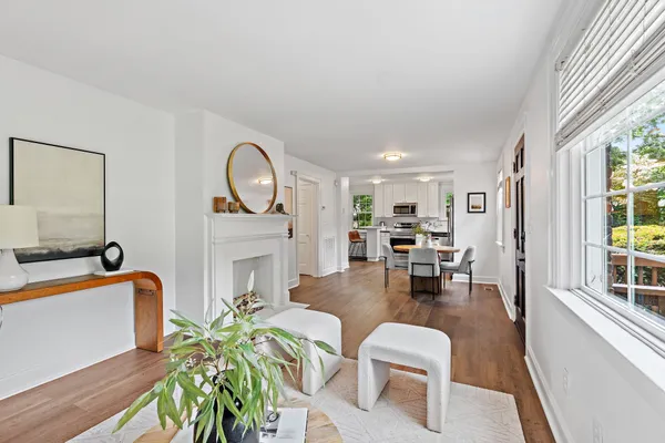 a living room with furniture a fireplace and a large window