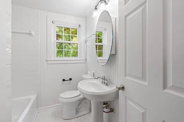 a bathroom with a toilet a sink and a window