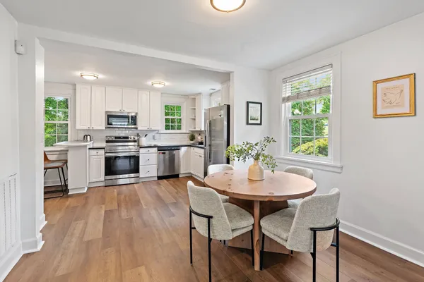 a kitchen with microwave a stove a table and chairs