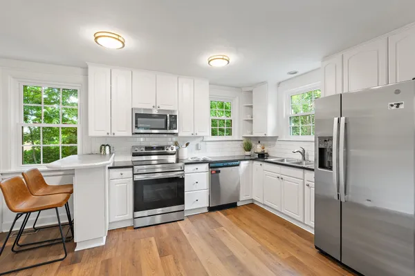 a kitchen with granite countertop a stove a sink and a refrigerator