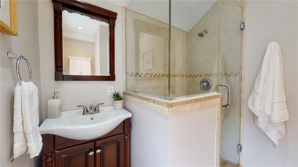 1321 Reddour Street Pittsburgh, PA 15212 - Photo 11 of 21 a bathroom with a sink a mirror a vanity and a shower