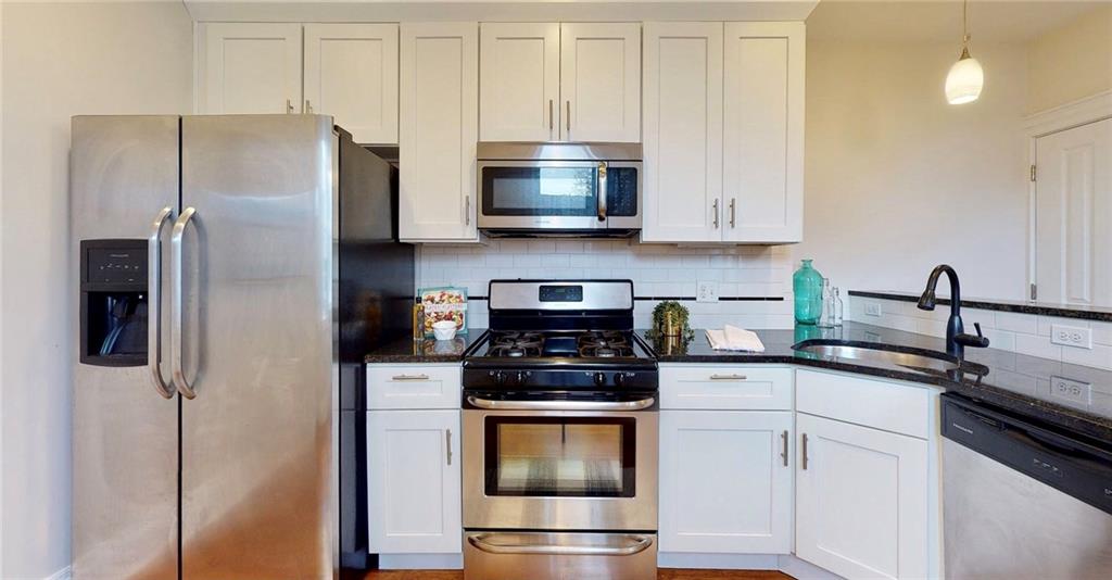 1321 Reddour Street Pittsburgh, PA 15212 - Photo 7 of 21 a kitchen with stainless steel appliances granite countertop a stove a refrigerator and a sink