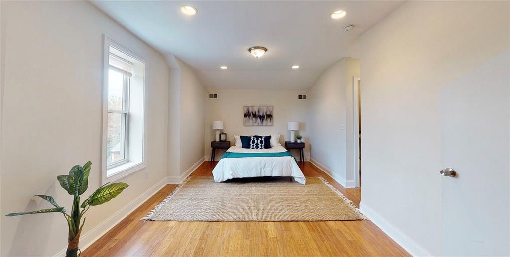 1321 Reddour Street Pittsburgh, PA 15212 - Photo 10 of 21 a room with a large bed and a wooden floor