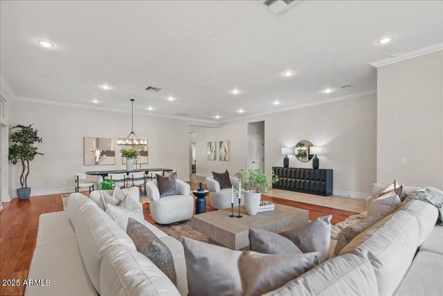 a dining room with furniture potted plants and wooden floor