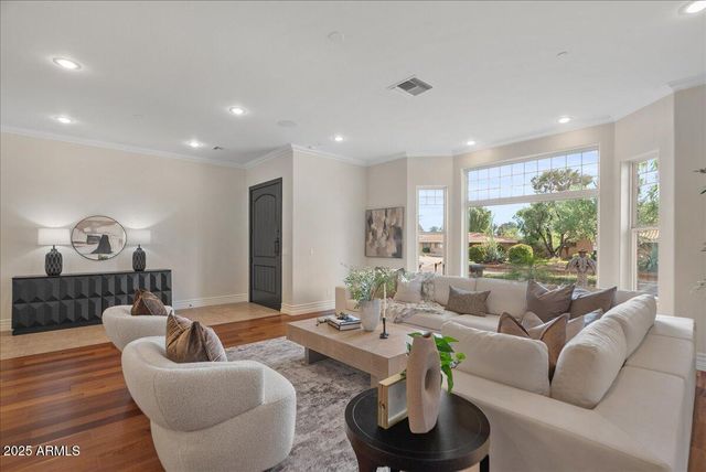 a dining room with furniture a chandelier and wooden floor
