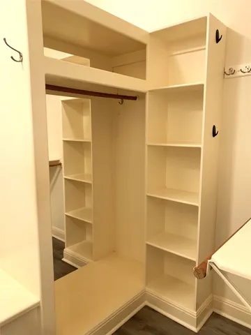 a view of walk in closet with empty racks