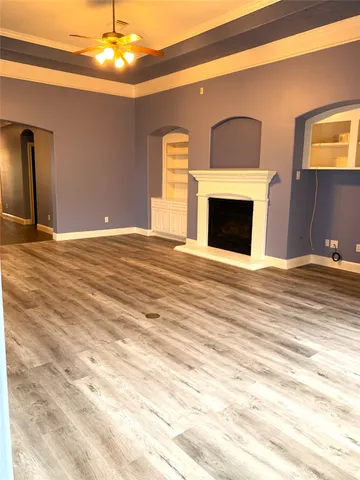 a view of an empty room with a fireplace and chandelier