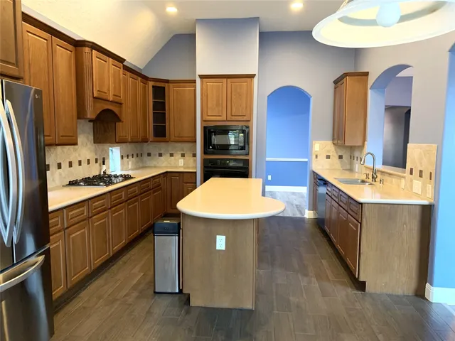 a kitchen with stainless steel appliances a sink stove and refrigerator