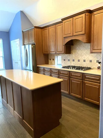 a kitchen with stainless steel appliances wooden cabinets a sink and a stove