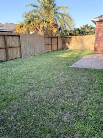a view of a backyard with wooden fence