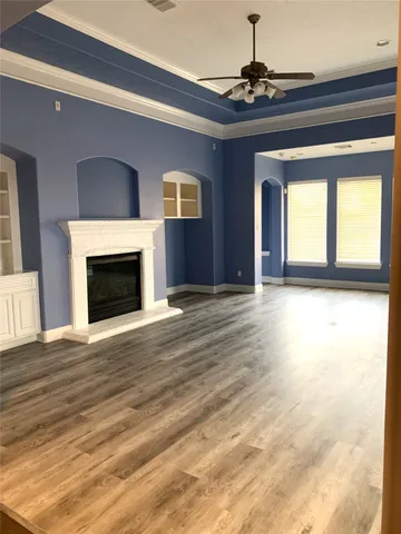 a view of empty room with wooden floor and fireplace