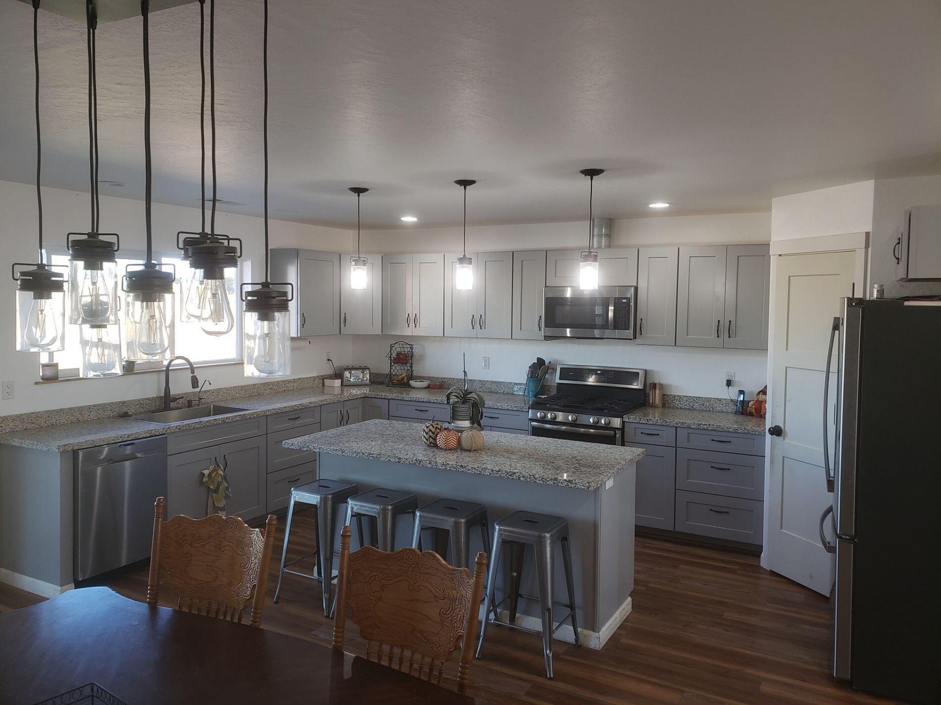 6188 Upton Road Central Point, OR 97502 - Photo 5 of 10 a kitchen with refrigerator a stove a sink cabinets and a dining table