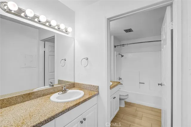 a bathroom with a granite countertop sink a mirror a shower and a bathtub