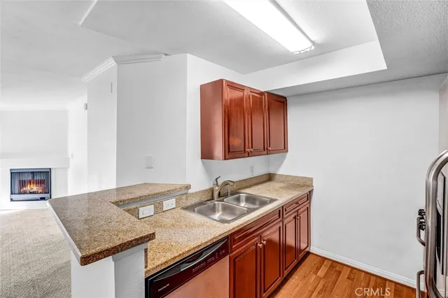 a kitchen with granite countertop a sink a stove and a wooden floor