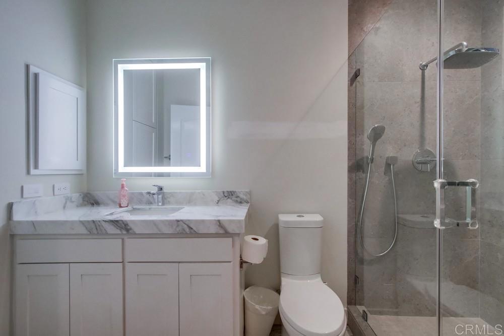 4124 Stonebridge Lane Rancho Santa Fe, CA 92091 - Photo 23 of 31 a bathroom with a toilet sink vanity and shower
