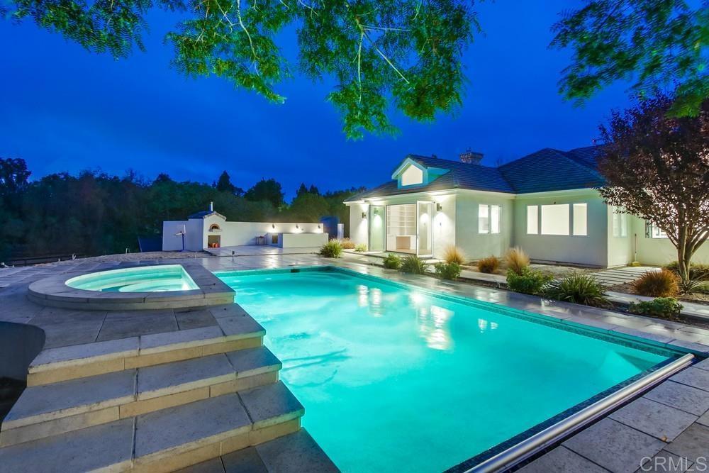 4124 Stonebridge Lane Rancho Santa Fe, CA 92091 - Photo 4 of 31 a view of a swimming pool with lawn chairs and a fire pit