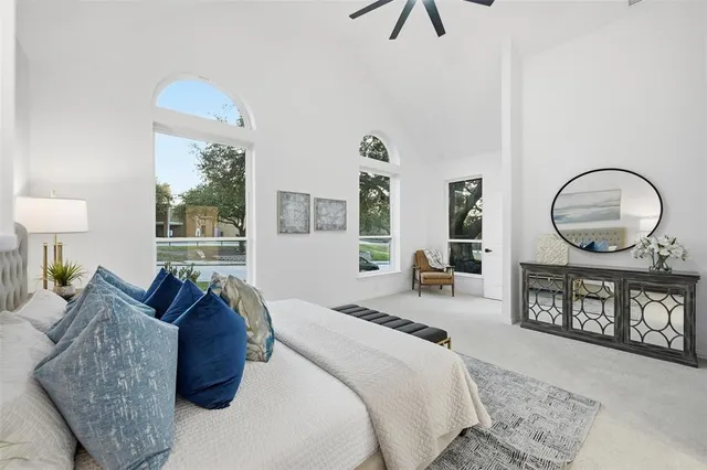 a bedroom with bed a mirror and a window