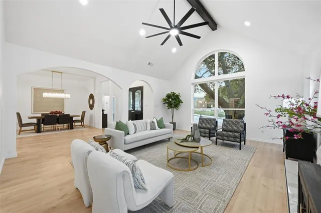 a living room with furniture a chandelier and a large window