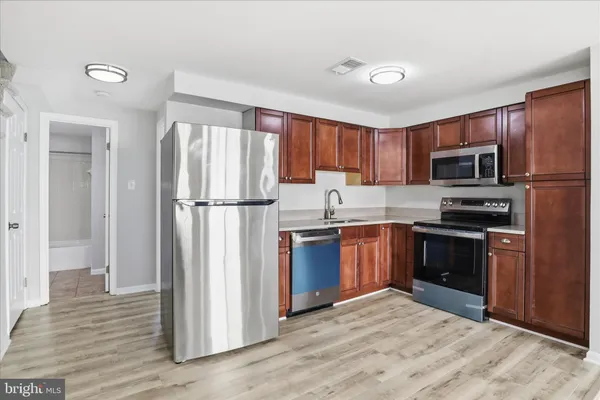 a kitchen with granite countertop a refrigerator stove and microwave