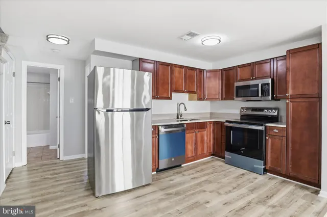 a kitchen with granite countertop a refrigerator stove and microwave