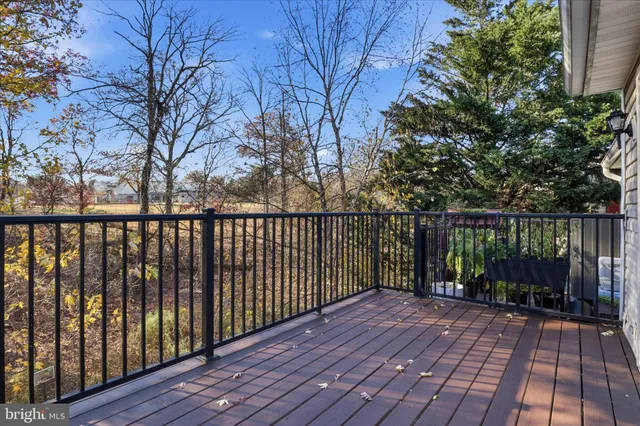 a balcony with wooden floor next to a yard
