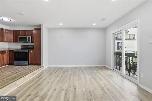 a view of kitchen with wooden floor and electronic appliances