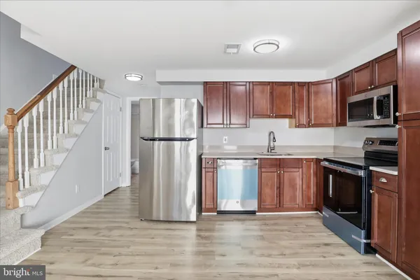 a kitchen with granite countertop a refrigerator and a stove top oven