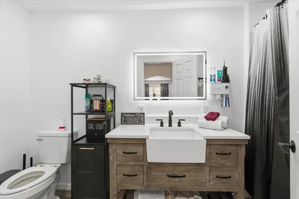 a bathroom with a sink toilet and mirror