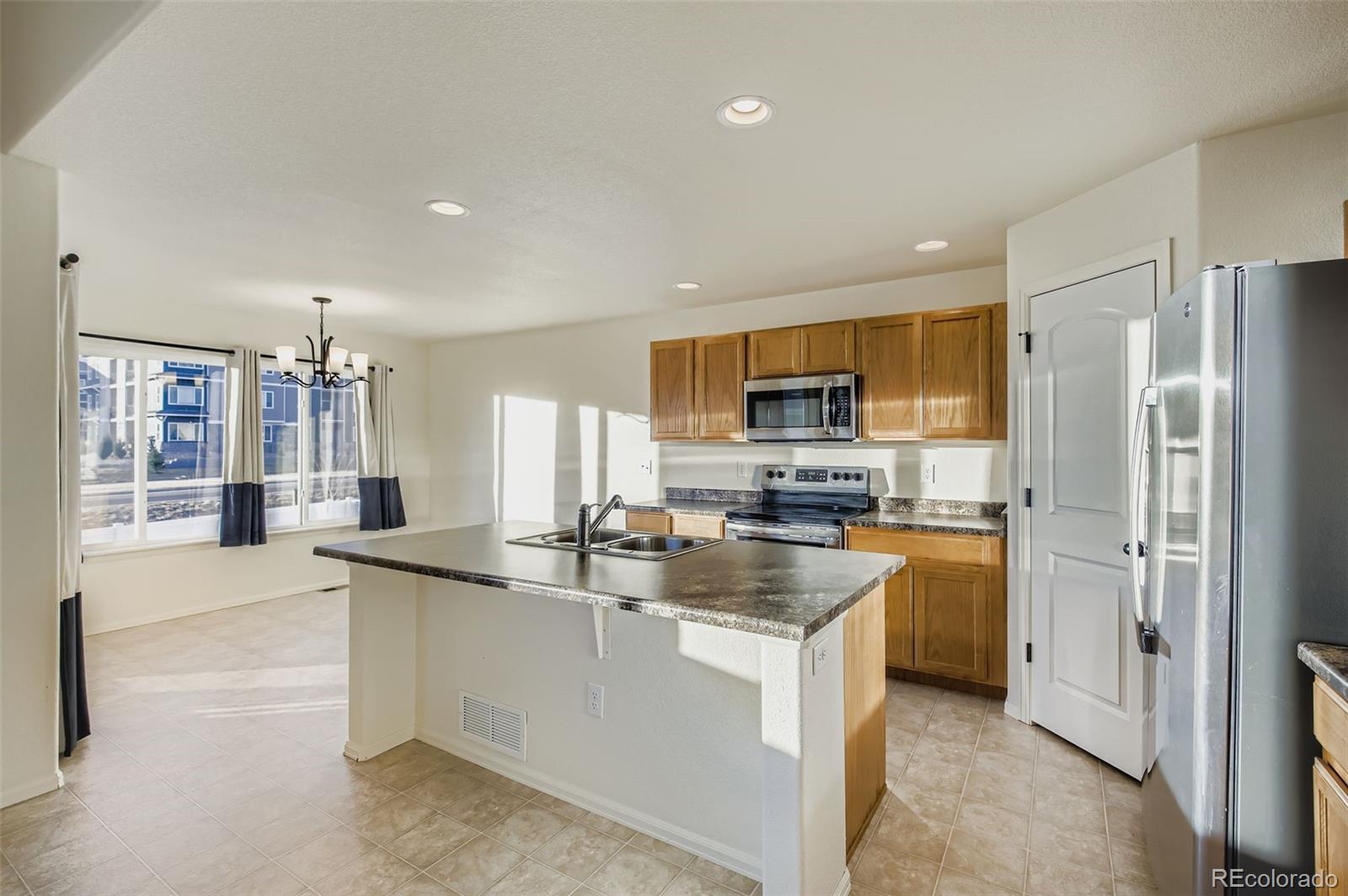 10300 19th St Road Greeley, CO 80634 - Photo 13 of 33 a kitchen with stainless steel appliances granite countertop a sink a stove and refrigerator