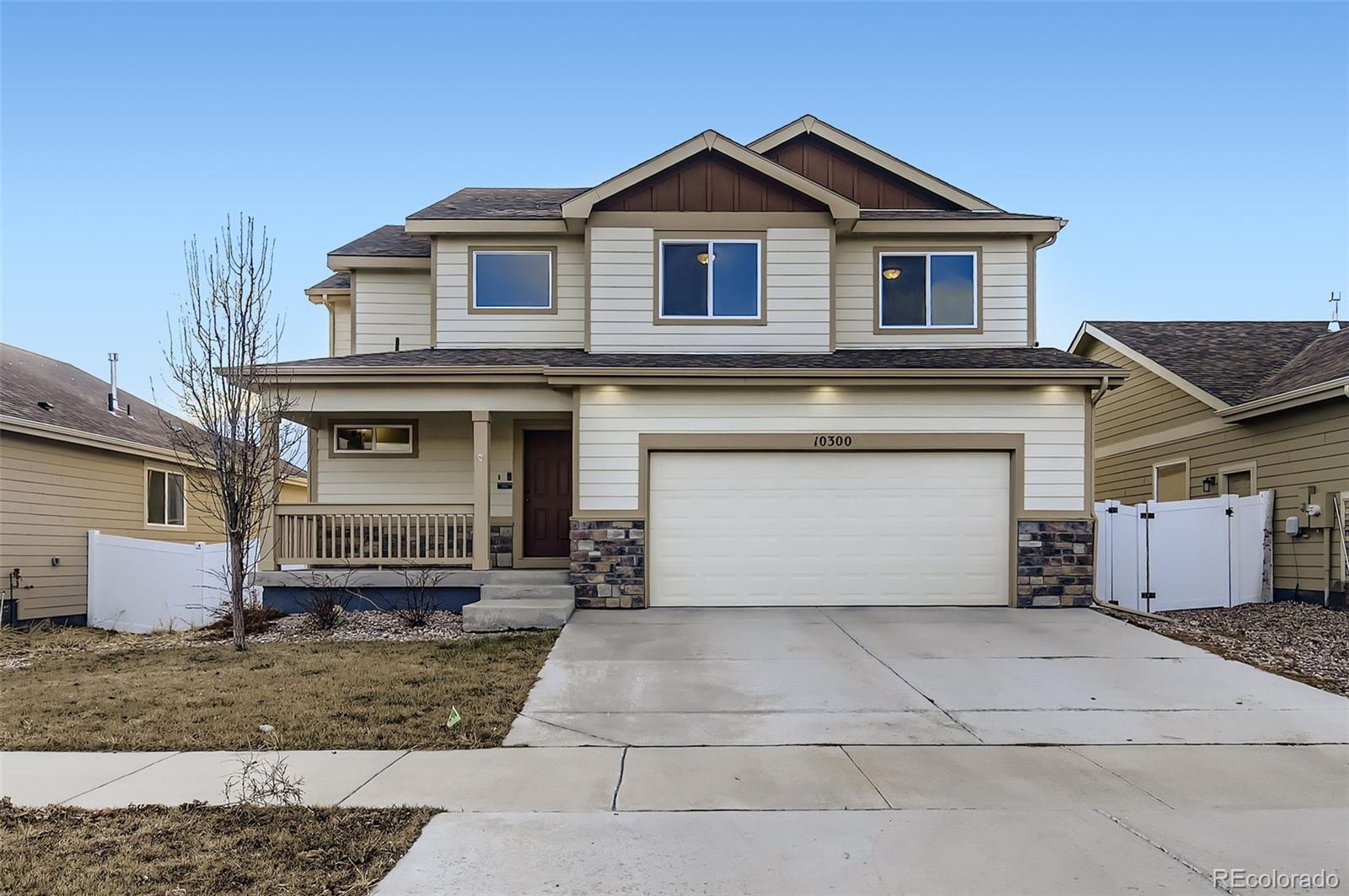10300 19th St Road Greeley, CO 80634 - Photo 2 of 33 a front view of a house with a yard and garage