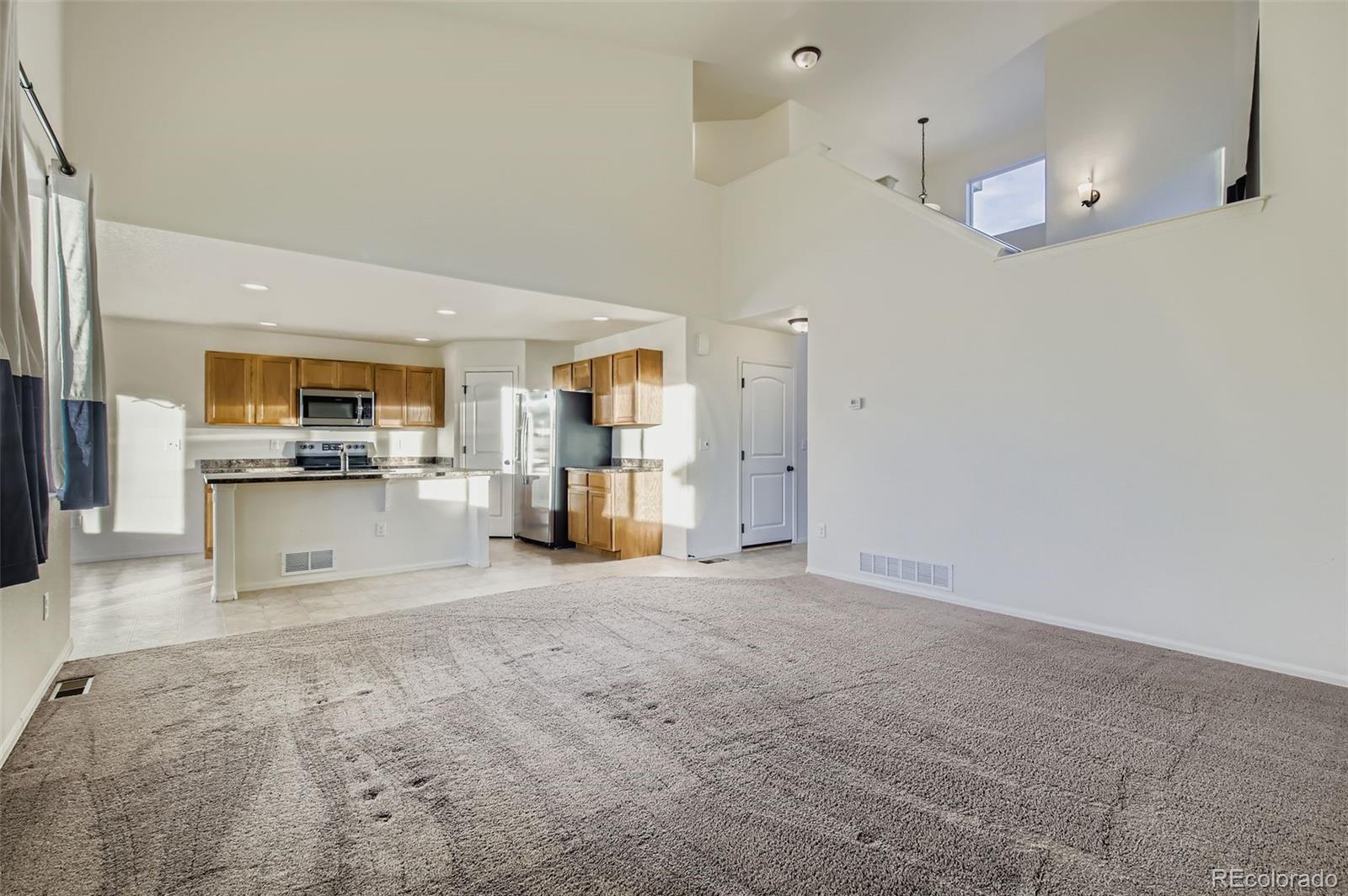10300 19th St Road Greeley, CO 80634 - Photo 9 of 33 a view of a kitchen with refrigerator and wooden floor