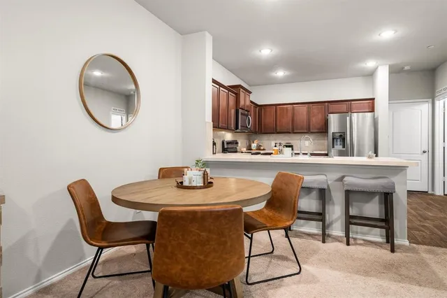 a kitchen with a dining table chairs and a kitchen view