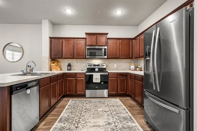 a kitchen with stainless steel appliances granite countertop a refrigerator stove top oven and sink