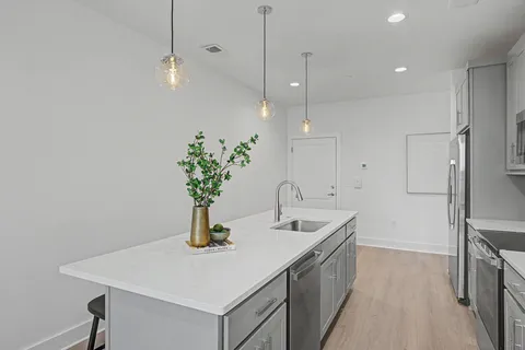 a kitchen with stainless steel appliances a sink a counter space and wooden floor