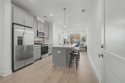 a kitchen with kitchen island white cabinets and stainless steel appliances