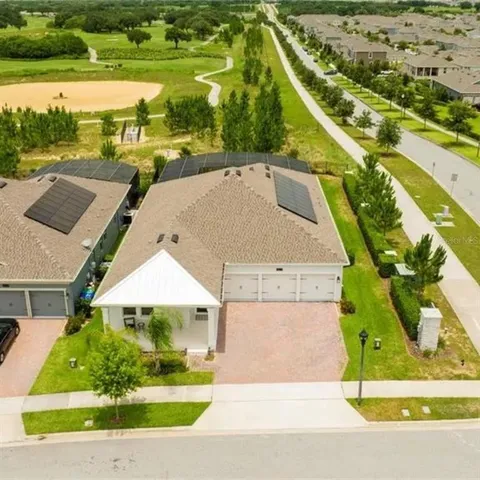 an aerial view of a house with a yard and lake view