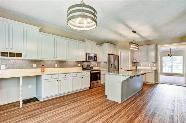 a large kitchen with stainless steel appliances granite countertop a stove and a sink