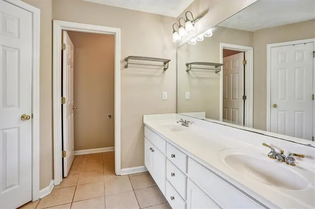 a spacious bathroom with a double vanity sink mirror and shower