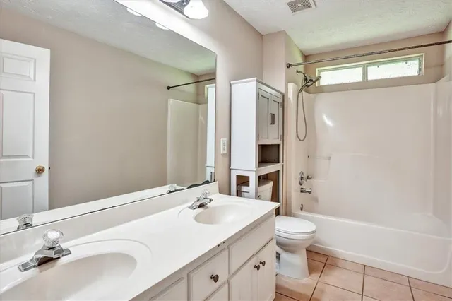 a bathroom with a sink toilet double vanity and shower