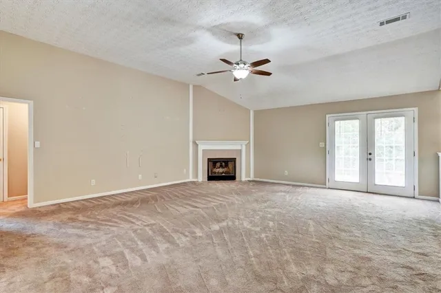 a view of an empty room with a fireplace and a window