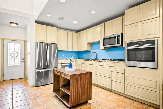 a kitchen with stainless steel appliances a stove a sink and a microwave