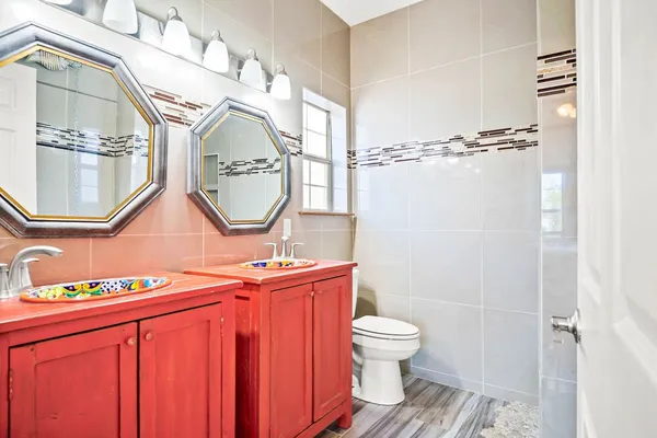 a bathroom with a toilet a sink and a mirror