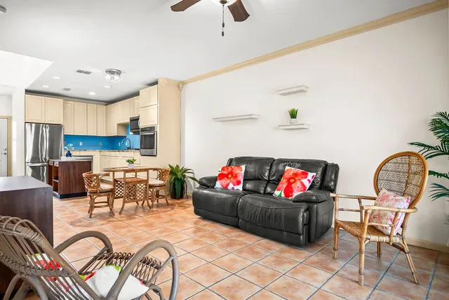 a living room with furniture kitchen view and a chandelier