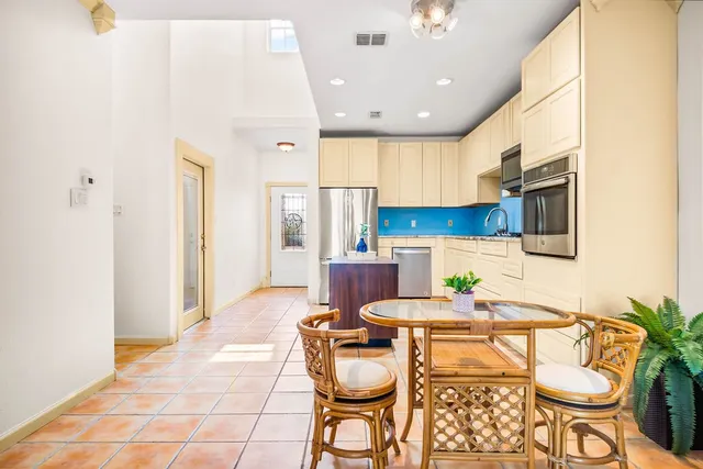 a kitchen with stainless steel appliances kitchen island granite countertop a refrigerator and a stove