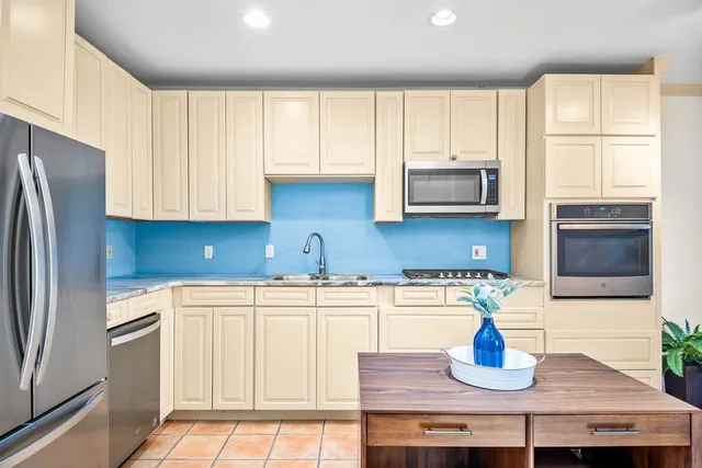 a kitchen with stainless steel appliances granite countertop a refrigerator sink and cabinets