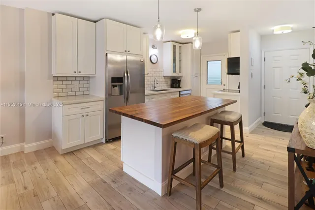 a view of a kitchen with a sink wooden floor and a mirror