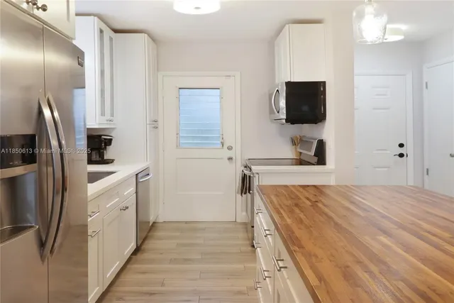 a view of kitchen cabinets and stainless steel appliances