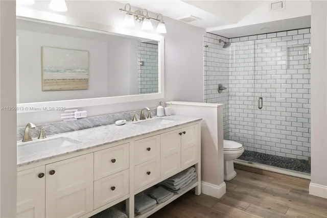 a bathroom with a double vanity sink a mirror and a shower