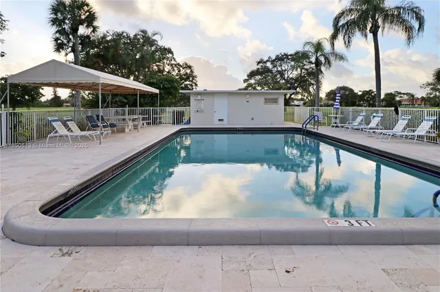 a view of a house with a small yard and large trees