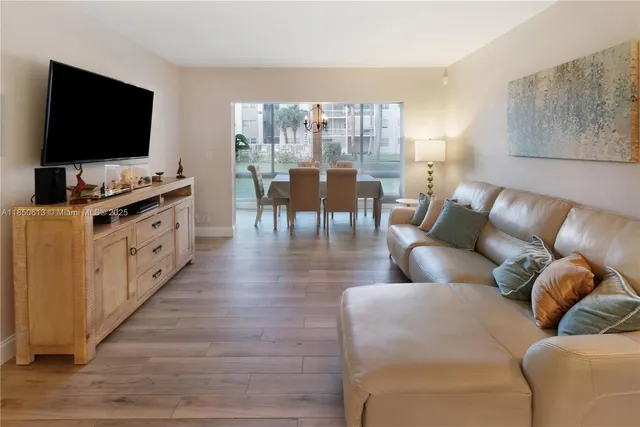 a dining room with furniture large windows and wooden floor